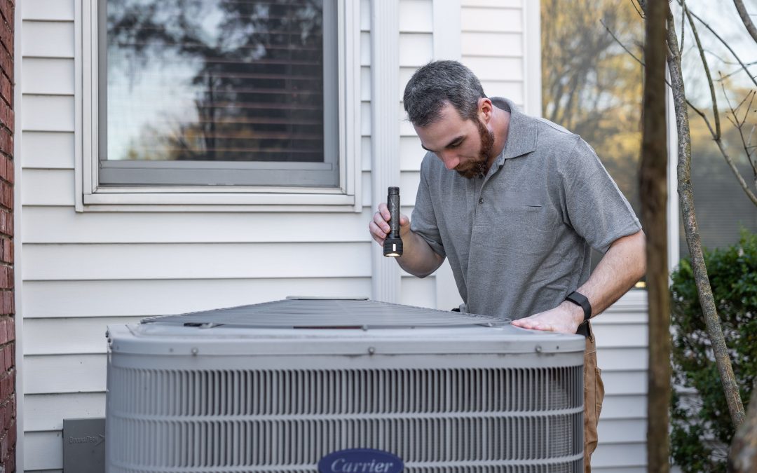 A technician inspects an outdoor HVAC unit for maintenance