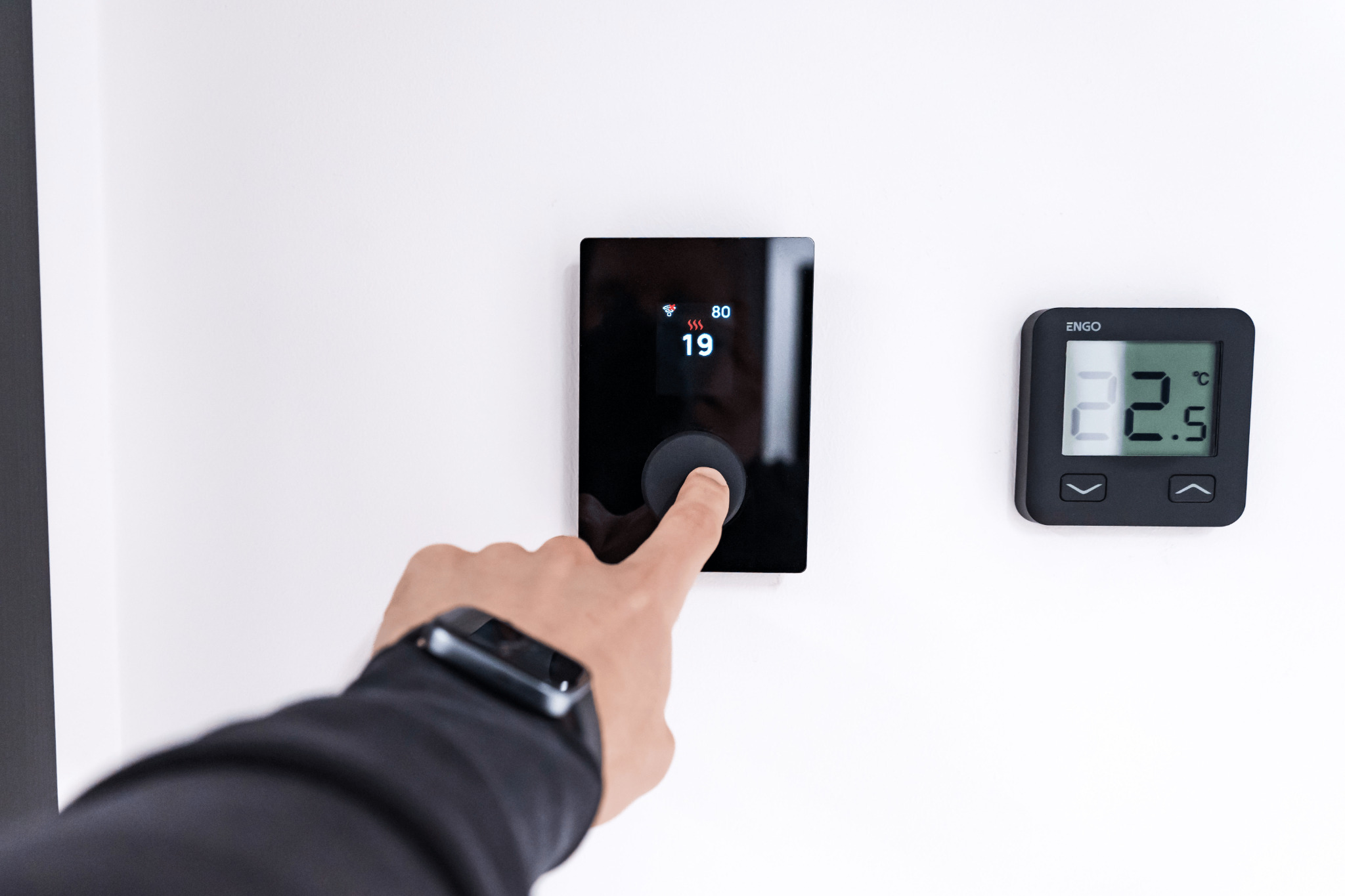 A smart thermostat mounted on a residential wall controlling an HVAC system
